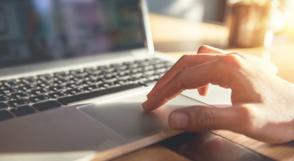 Woman hand on laptop trackpad